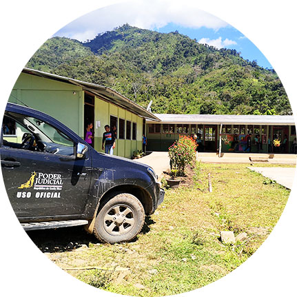 Carro del Poder Judicial estacionado en las afueras de un centro educativo