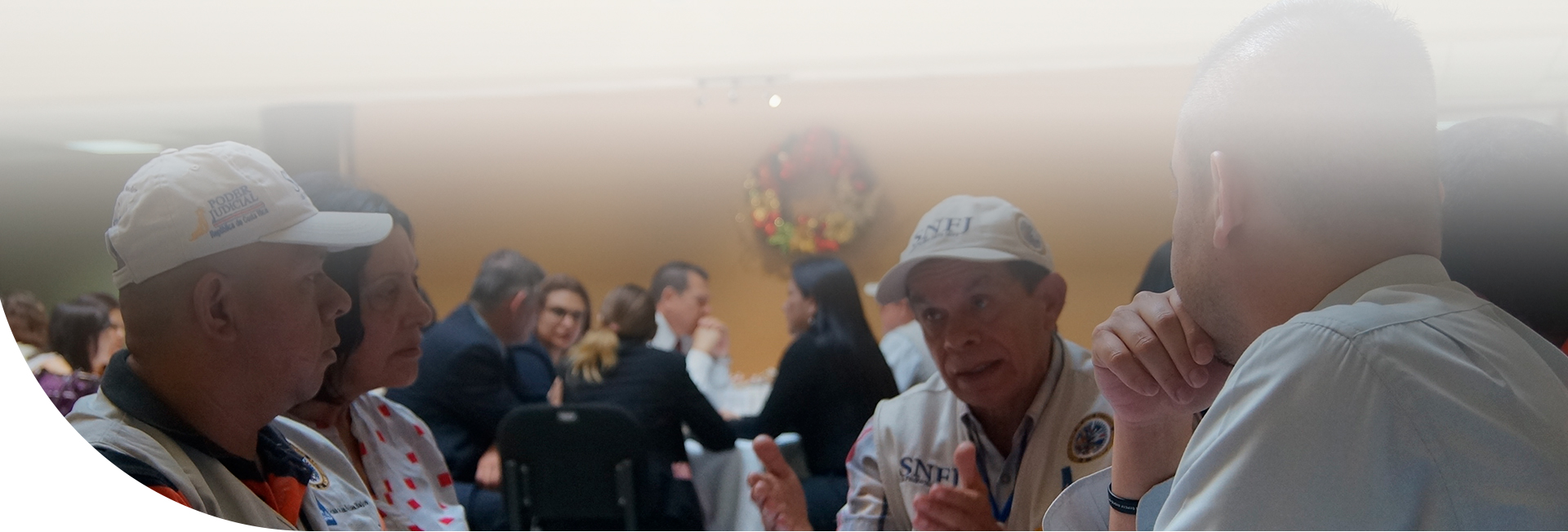 Tres hombres y una mujer conversando en una mesa
