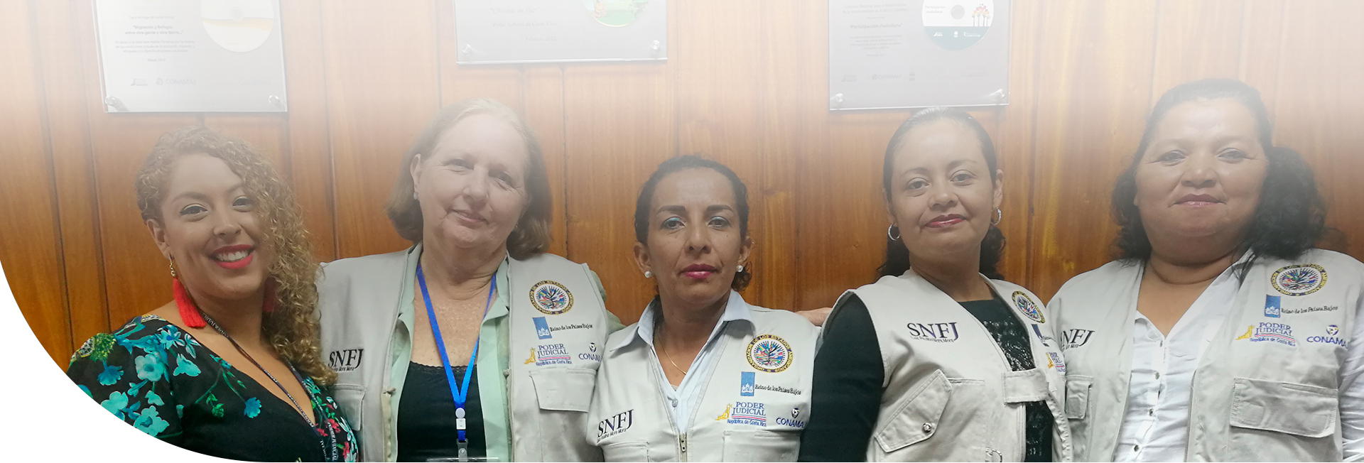 Grupo de cinco mujeres sonriendo posando para la cámara
