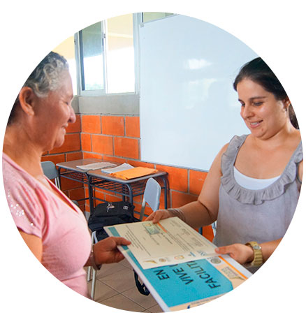 Dos mujeres sosteniendo un rótulo y unos documentos